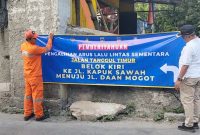 Foto Lurah Kapuk M.Arief Budiman saat memasang spanduk informasi di Tanggul Timur kelurahan Kapuk, Cengkareng, Jakarta Barat (26/4/2026)