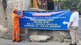 Foto Lurah Kapuk M.Arief Budiman saat memasang spanduk informasi di Tanggul Timur kelurahan Kapuk, Cengkareng, Jakarta Barat (26/4/2026)