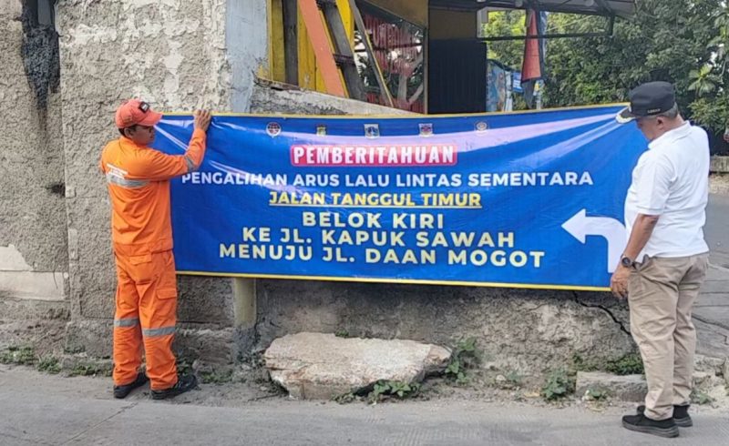 Foto Lurah Kapuk M.Arief Budiman saat memasang spanduk informasi di Tanggul Timur kelurahan Kapuk, Cengkareng, Jakarta Barat (26/4/2026)