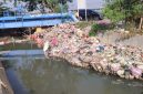 Foto sampah yang menumpuk di bantaran kali Parimeter 