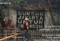 Seorang warga sedang memperbaiki pagar taman yang rusak