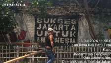 Seorang warga sedang memperbaiki pagar taman yang rusak