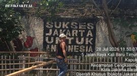 Seorang warga sedang memperbaiki pagar taman yang rusak