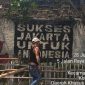 Seorang warga sedang memperbaiki pagar taman yang rusak