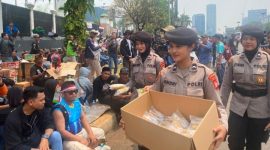 Momen sejumlah Polisi Wanita (Polwan) bagikan makanan dan minuman ke peserta aksi di DPR RI yang tengah duduk dan beristirahat. 
