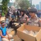 Momen sejumlah Polisi Wanita (Polwan) bagikan makanan dan minuman ke peserta aksi di DPR RI yang tengah duduk dan beristirahat. 